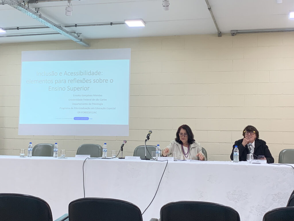 Photograph showing two people at a themed table in a dining room. The room is well lit and has light-colored walls and ceiling. End of description.